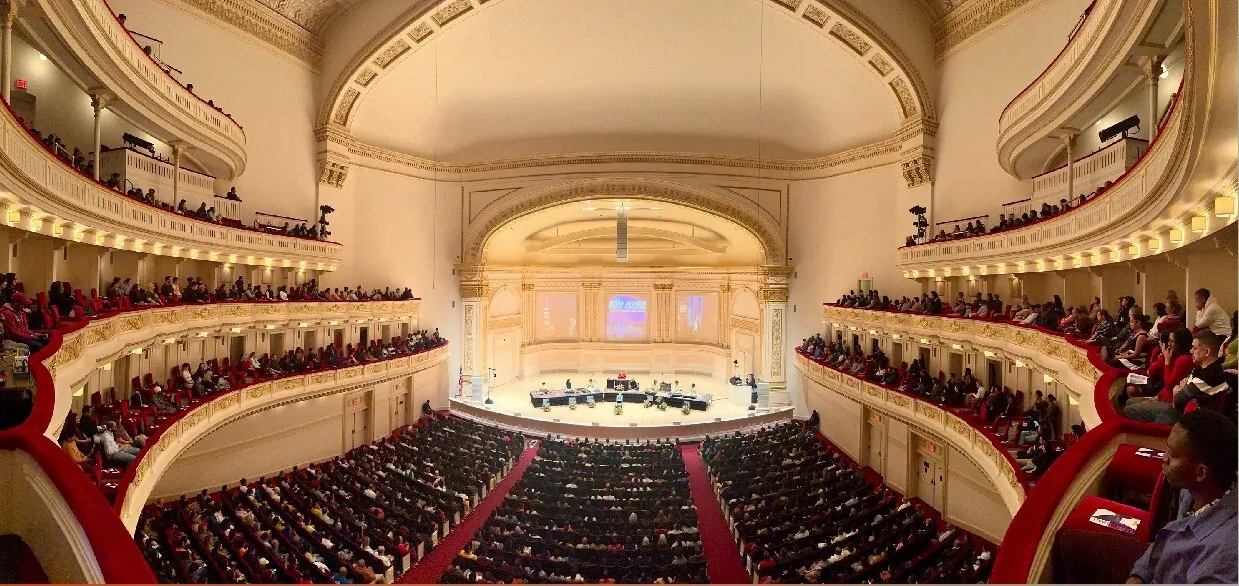 Panoramic view of the Carnegie Hall auditorium, New York, with a full audience and the ensemble on stage, 2 December 2023.