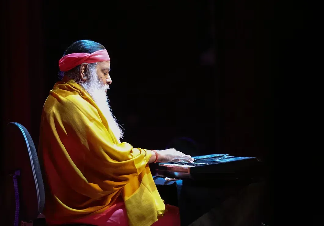 Sri Ganapathy Sachchidananda Swamiji performing at the keyboard.